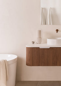 cropped shot of a soft tonal bathroom with florentine walnut curved floating vanity, vessel sink and bath